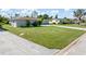 Exterior front yard view of two houses showcasing lush green lawns, concrete driveways, and sidewalks at 123 Annapolis Ln, Rotonda West, FL 33947