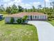 Charming single-story home with a well-manicured lawn, long driveway, and a welcoming facade at 123 Annapolis Ln, Rotonda West, FL 33947