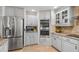 Kitchen with stainless steel refrigerator, double oven and custom cabinetry at 123 Annapolis Ln, Rotonda West, FL 33947