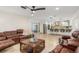 Open-concept living room with leather furniture, ceiling fan and seamless transition into a gourmet kitchen at 123 Annapolis Ln, Rotonda West, FL 33947