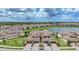 An aerial view showcasing lovely townhomes with red tile roofs, brick driveways, and scenic water views, set in a neatly planned community at 12425 Ghiberti Cir # 101, Venice, FL 34293