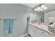Bright bathroom features blue walls, a vanity with decorative flowers, and a well-lit mirror, offering a serene space at 12425 Ghiberti Cir # 101, Venice, FL 34293