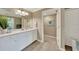 Bright bathroom features white cabinets, a large mirror, and modern fixtures, creating a clean and inviting space at 12425 Ghiberti Cir # 101, Venice, FL 34293