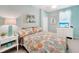 Relaxing bedroom features a floral patterned bedspread, soft blue walls, and a TV for entertainment at 12425 Ghiberti Cir # 101, Venice, FL 34293