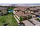 Aerial view of home with red-tiled roof, brick driveway, and lush landscaping, near a peaceful pond in a planned community at 12425 Ghiberti Cir # 101, Venice, FL 34293