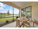 Relaxing screened lanai with a view of the lake, featuring a dining table and comfortable seating, perfect for outdoor enjoyment at 12425 Ghiberti Cir # 101, Venice, FL 34293