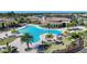 An aerial view highlights a large community pool surrounded by palm trees, lounge chairs, and well-maintained landscaping at 12425 Ghiberti Cir # 101, Venice, FL 34293
