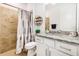Bathroom with tiled shower and floors, and white vanity with granite countertops at 14684 Cherry Blossom Way, Punta Gorda, FL 33955