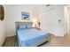 Comfortable bedroom featuring stylish wood-look tile flooring, a serene blue color scheme, and a coastal-themed wall decor at 14684 Cherry Blossom Way, Punta Gorda, FL 33955