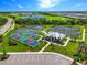 Aerial view showcasing tennis and pickleball courts, lush landscaping, and community center for active living at 14684 Cherry Blossom Way, Punta Gorda, FL 33955