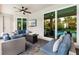 Relaxing patio space with ample seating, TV, ceiling fans, and views of the lush outdoor scenery at 14684 Cherry Blossom Way, Punta Gorda, FL 33955