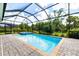 Screened-in pool featuring a spa and brick pavers, creating a luxurious outdoor oasis at 14684 Cherry Blossom Way, Punta Gorda, FL 33955