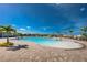 Stunning pool with lounge seating and palm trees under a vibrant blue sky in Heritage Landing at 14684 Cherry Blossom Way, Punta Gorda, FL 33955