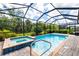 Screened-in pool area featuring a spa and clear blue water, offering a refreshing retreat at 14684 Cherry Blossom Way, Punta Gorda, FL 33955