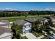 Aerial view of a two-story blue home with palm trees and lush landscaping in a vibrant neighborhood at 17032 Yellow Pine St, Wimauma, FL 33598