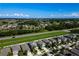 Aerial view of a neighborhood with homes, a roadway, and a greenbelt on a clear day at 17032 Yellow Pine St, Wimauma, FL 33598