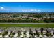 Aerial shot of a residential neighborhood near a greenbelt and roadway on a bright sunny day at 17032 Yellow Pine St, Wimauma, FL 33598
