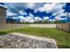 A spacious backyard with a well-maintained lawn, privacy fence, and a paved patio area perfect for outdoor entertaining at 17032 Yellow Pine St, Wimauma, FL 33598