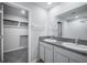 Bright bathroom featuring tiled floors, granite countertops, double vanity and open access to closet with installed shelving at 17032 Yellow Pine St, Wimauma, FL 33598