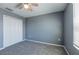 A cozy bedroom with modern gray carpet, white closet doors and a ceiling fan for comfort at 17032 Yellow Pine St, Wimauma, FL 33598