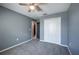 Cozy bedroom featuring plush gray carpeting, a ceiling fan, and a closet with bi-fold doors at 17032 Yellow Pine St, Wimauma, FL 33598