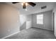 Upstairs bedroom features plush gray carpeting, neutral walls, a ceiling fan, and a bright window view at 17032 Yellow Pine St, Wimauma, FL 33598