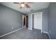 Cozy bedroom featuring plush gray carpeting, a ceiling fan, and a closet with open bi-fold doors at 17032 Yellow Pine St, Wimauma, FL 33598