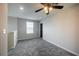 Upstairs bedroom features plush gray carpeting, neutral walls, a ceiling fan, and a bright window view at 17032 Yellow Pine St, Wimauma, FL 33598