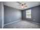 This bedroom features a ceiling fan, a window, and plush gray carpet for comfort at 17032 Yellow Pine St, Wimauma, FL 33598