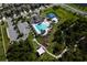 Aerial view featuring the pool, tennis courts, playground, and surrounding greenery, a hub for recreation and relaxation at 17032 Yellow Pine St, Wimauma, FL 33598