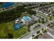 A top-down aerial view of a community pool, tennis courts, playground, and surrounding neighborhood at 17032 Yellow Pine St, Wimauma, FL 33598