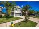 Charming two-story home featuring a gray color scheme, attached two-car garage, and tropical landscaping at 17032 Yellow Pine St, Wimauma, FL 33598