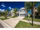 Charming two-story home featuring a gray color scheme, attached two-car garage, and tropical landscaping at 17032 Yellow Pine St, Wimauma, FL 33598