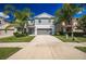 Charming two-story home featuring a gray color scheme, attached two-car garage, and tropical landscaping at 17032 Yellow Pine St, Wimauma, FL 33598