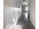 A bright hallway featuring neutral paint, decorative wood-paneled wall, dark doors, and tile flooring throughout at 17032 Yellow Pine St, Wimauma, FL 33598
