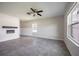 Open concept living room featuring tile floors, a ceiling fan, large windows and a decorative fireplace at 17032 Yellow Pine St, Wimauma, FL 33598