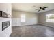 Bright living room with tiled floors, neutral paint, large windows, and a shiplap fireplace with dark wood mantle at 17032 Yellow Pine St, Wimauma, FL 33598