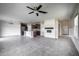 Spacious living room open to the kitchen featuring gray tile floors, modern lighting and a fireplace at 17032 Yellow Pine St, Wimauma, FL 33598