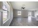 Spacious living room with tiled floors, neutral paint, large windows, and sliding glass doors leading to the backyard at 17032 Yellow Pine St, Wimauma, FL 33598