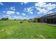 Expansive backyard with a green lawn, beautiful landscaping and screened patio at 1915 Pebble Beach Ct, Venice, FL 34293