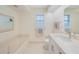 Bright bathroom featuring a soaking tub, neutral color palette and a tiled floor at 1915 Pebble Beach Ct, Venice, FL 34293