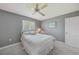Cozy bedroom with large window, neutral color palette, and ceiling fan at 1915 Pebble Beach Ct, Venice, FL 34293