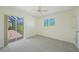 Airy bedroom with sliding glass doors and window with views of exterior at 1915 Pebble Beach Ct, Venice, FL 34293