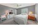 Cozy bedroom featuring a queen-size bed, a large window, and neutral-toned walls at 1915 Pebble Beach Ct, Venice, FL 34293