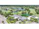 Aerial view of clubhouse surrounded by lush landscaping, ponds, and golf course at 1915 Pebble Beach Ct, Venice, FL 34293