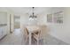 Dining room features a modern chandelier, neutral colors, and bright window at 1915 Pebble Beach Ct, Venice, FL 34293