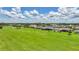 Scenic golf course view with lush green fairways and green lawns up to well-manicured homes at 1915 Pebble Beach Ct, Venice, FL 34293