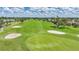 Beautiful golf course view with lush green fairways, sand traps and palm trees under a blue sky with fluffy clouds at 1915 Pebble Beach Ct, Venice, FL 34293