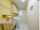 Functional laundry room with sink, washer, dryer, and storage shelves at 1915 Pebble Beach Ct, Venice, FL 34293