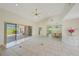 Bright open-concept living room with slider doors to a screened lanai with golf course views at 1915 Pebble Beach Ct, Venice, FL 34293